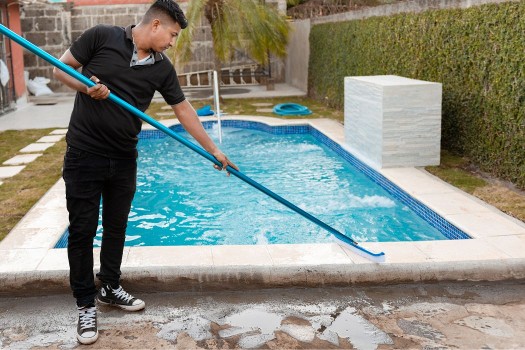 Man Cleaning Pool from outside