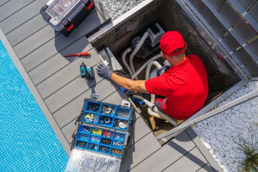 Man repairing the swimming pool cleaning and heating system